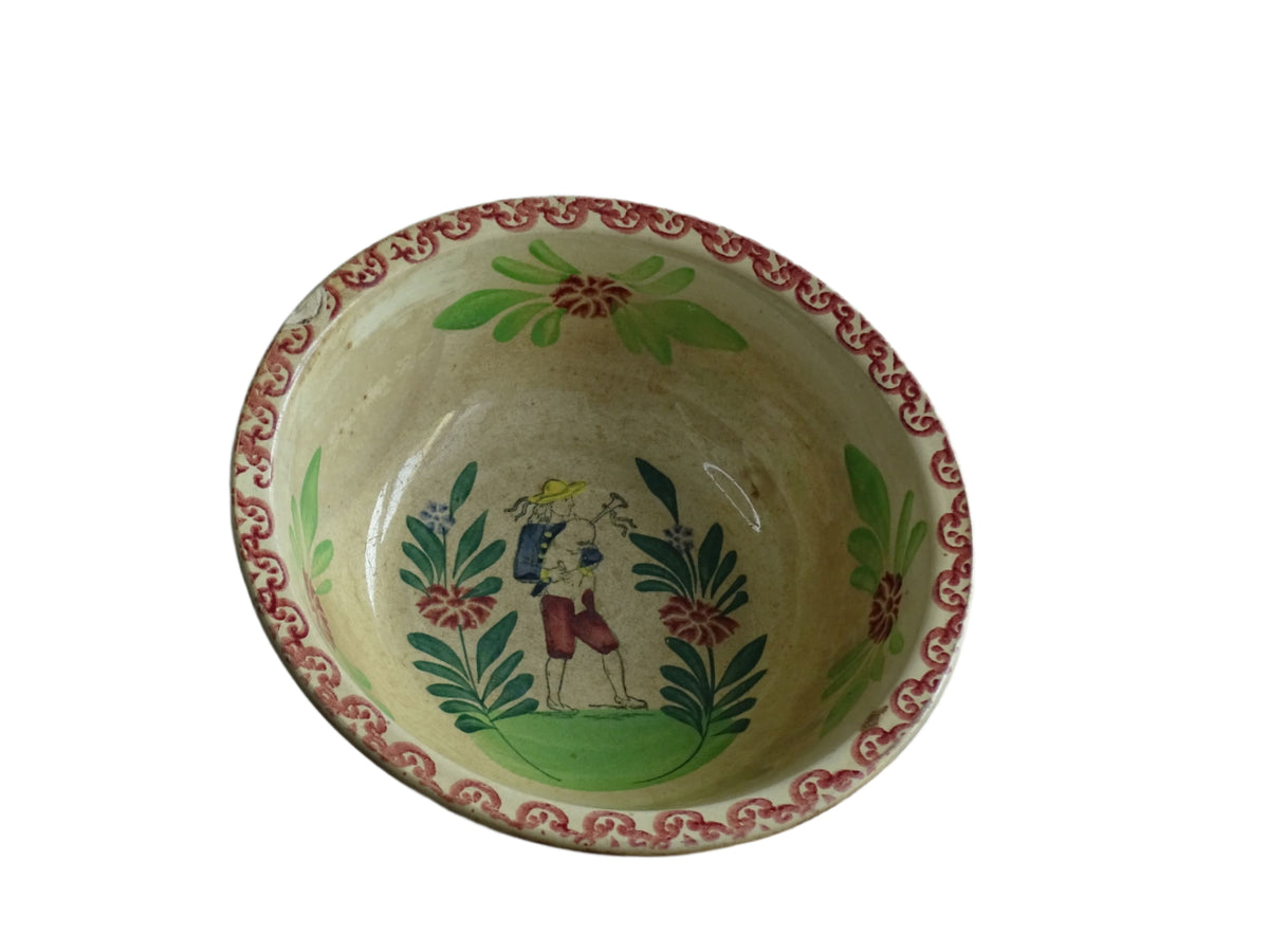 French antique ceramic salad bowl from Saint Amand. Hand-painted with a figure and decorated with leaves and flowers