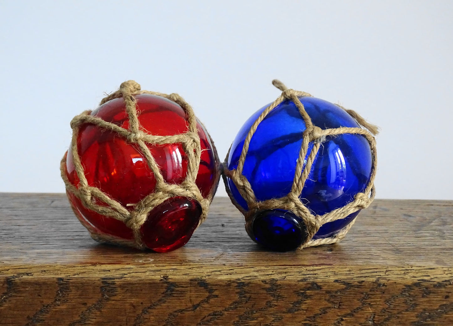 Pair of French vintage glass fishing floats in red and blue glass