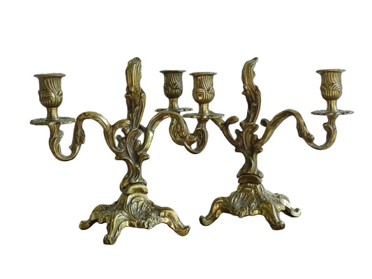 Pair of French antique brass candelabras in a rococo style. Early 20th century antique candelabras with space for two tapered candlesticks. Brass candle holders for dining table decor or living room decor.