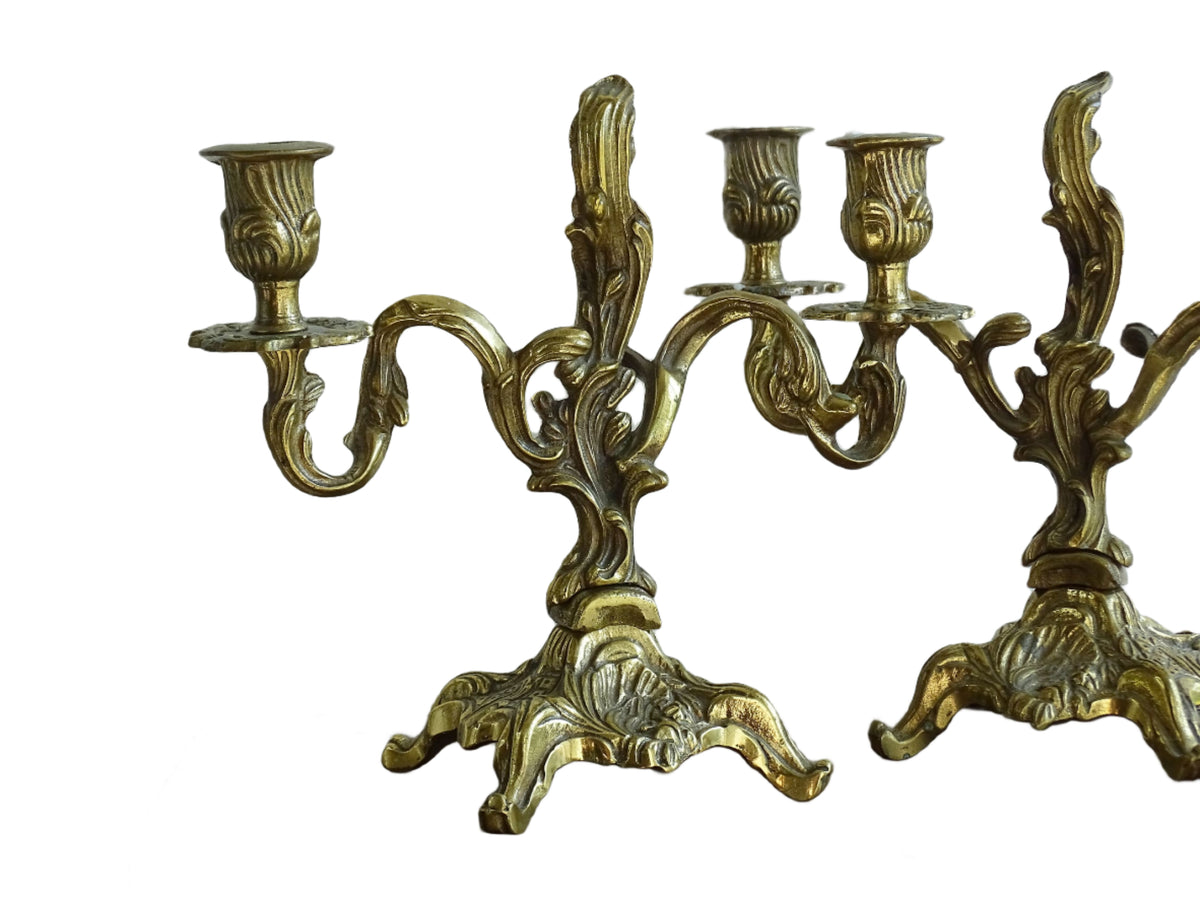 Pair of French antique brass candelabras in a rococo style. Early 20th century antique candelabras with space for two tapered candlesticks. Brass candle holders for dining table decor or living room decor.