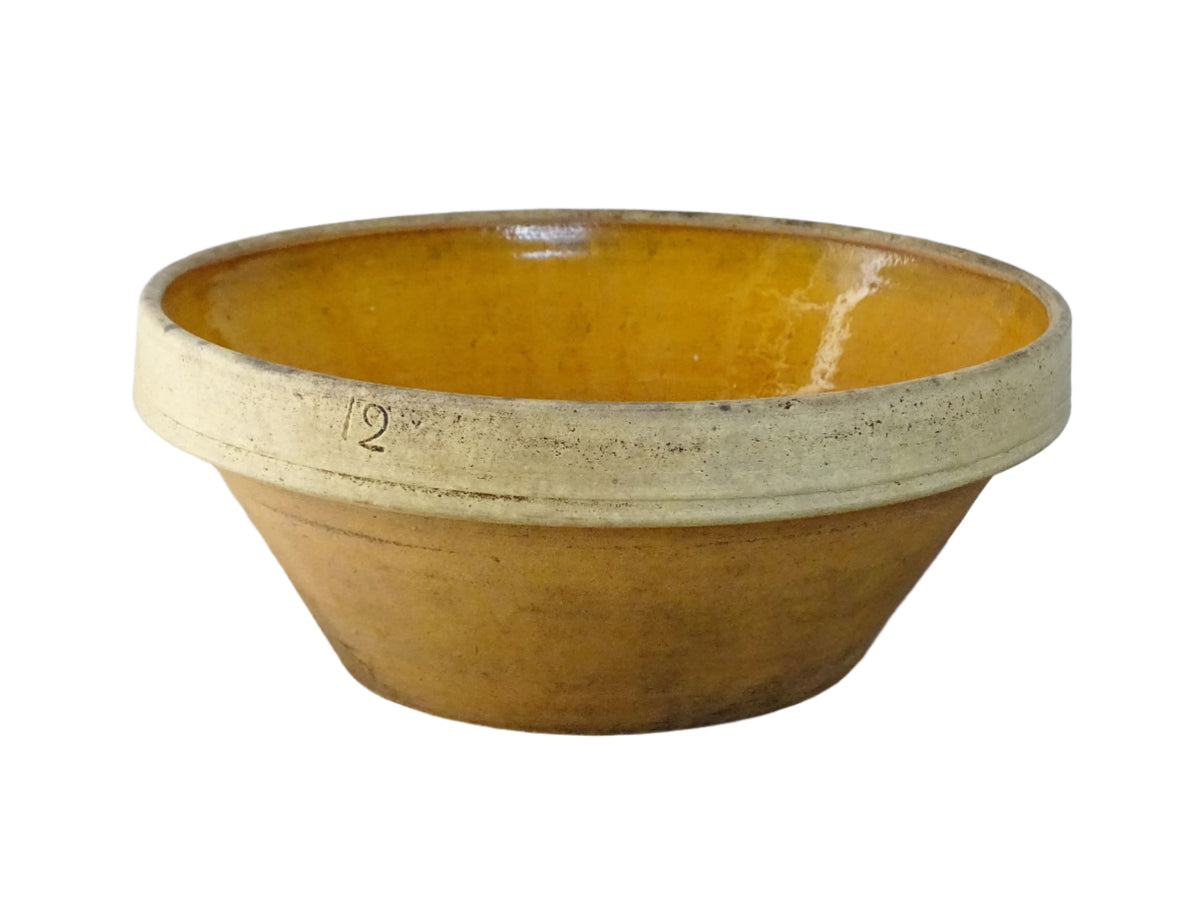 Rustic French antique ceramic mixing bowl with an orange glaze to the interior. Terracotta pottery bowl for a French country farmhouse kitchen.
