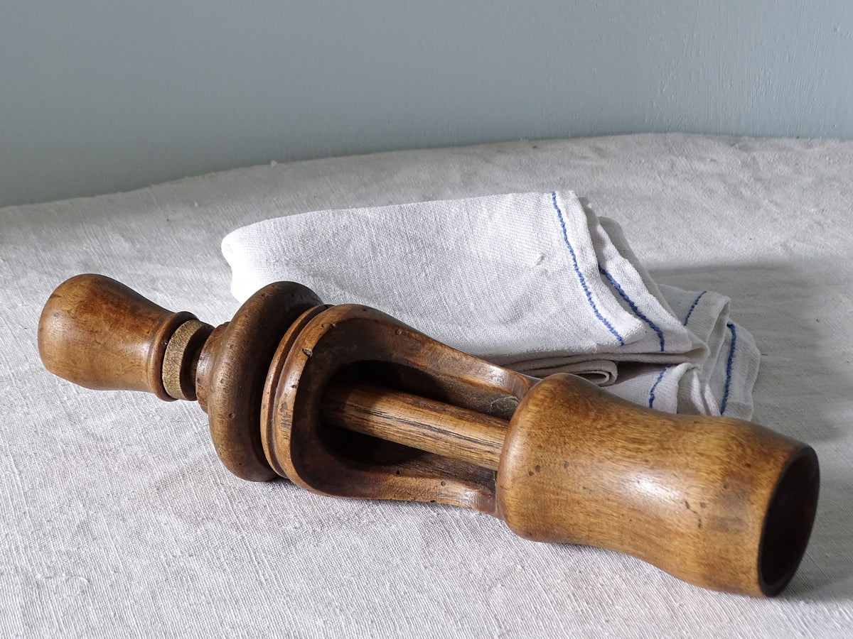 French antique wooden cork pusher, pictured with antique linen