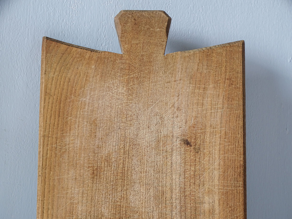 Close-up of vintage French cutting board surface showing numerous fine knife marks, scratches and naturally aged wood.