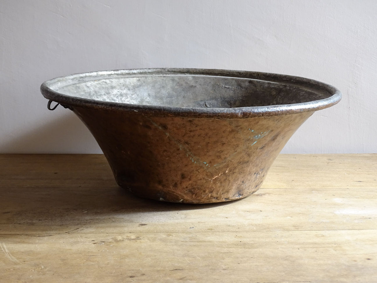 Large French antique copper bowl, it has an aged exterior with a warm patina and a tinned copper interior. It has a flared shape and substantial size. French farmhouse aesthetic decor.