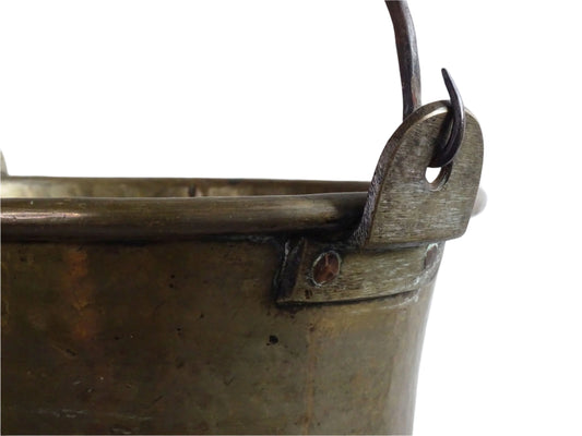 French antique brass cauldron with a hammered brass body and wrought iron handle, brass cooking pot ideal for farmhouse kitchen decor or rustic home decor, displayed on a wooden surface.