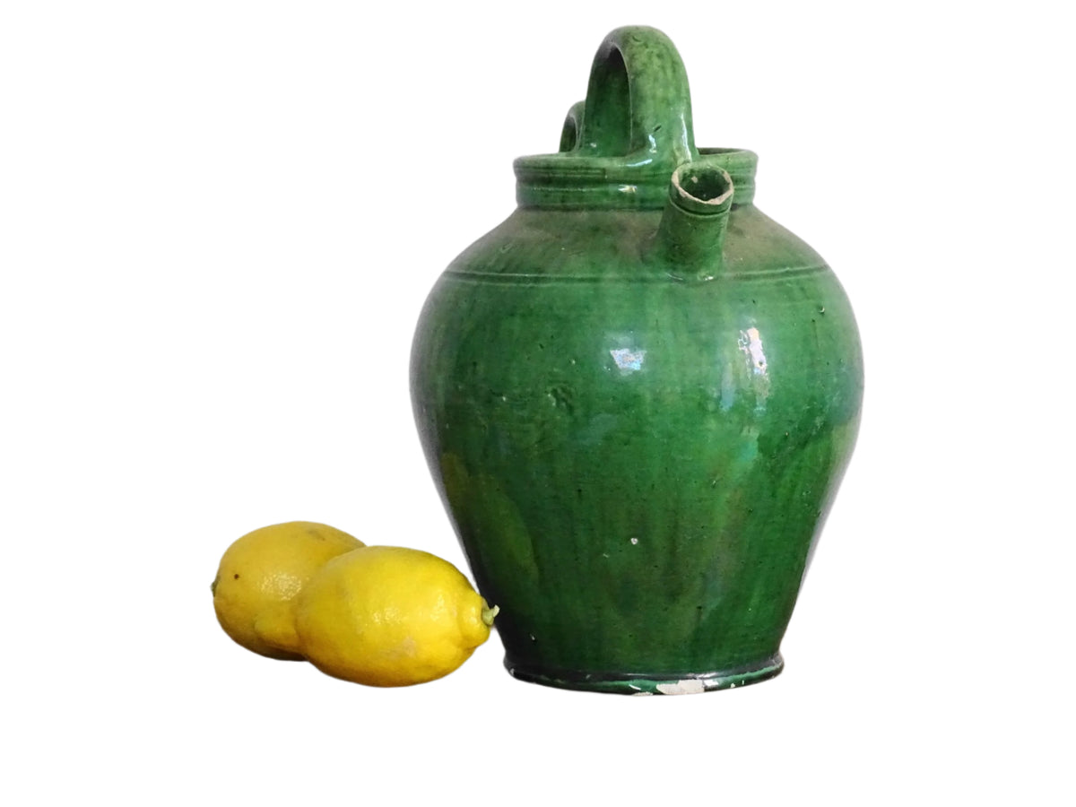 French antique gargoulette with green glaze from Provence. This antique Provençal water pitcher has a spout and two handles with a vivid green glaze. Pottery cruche.