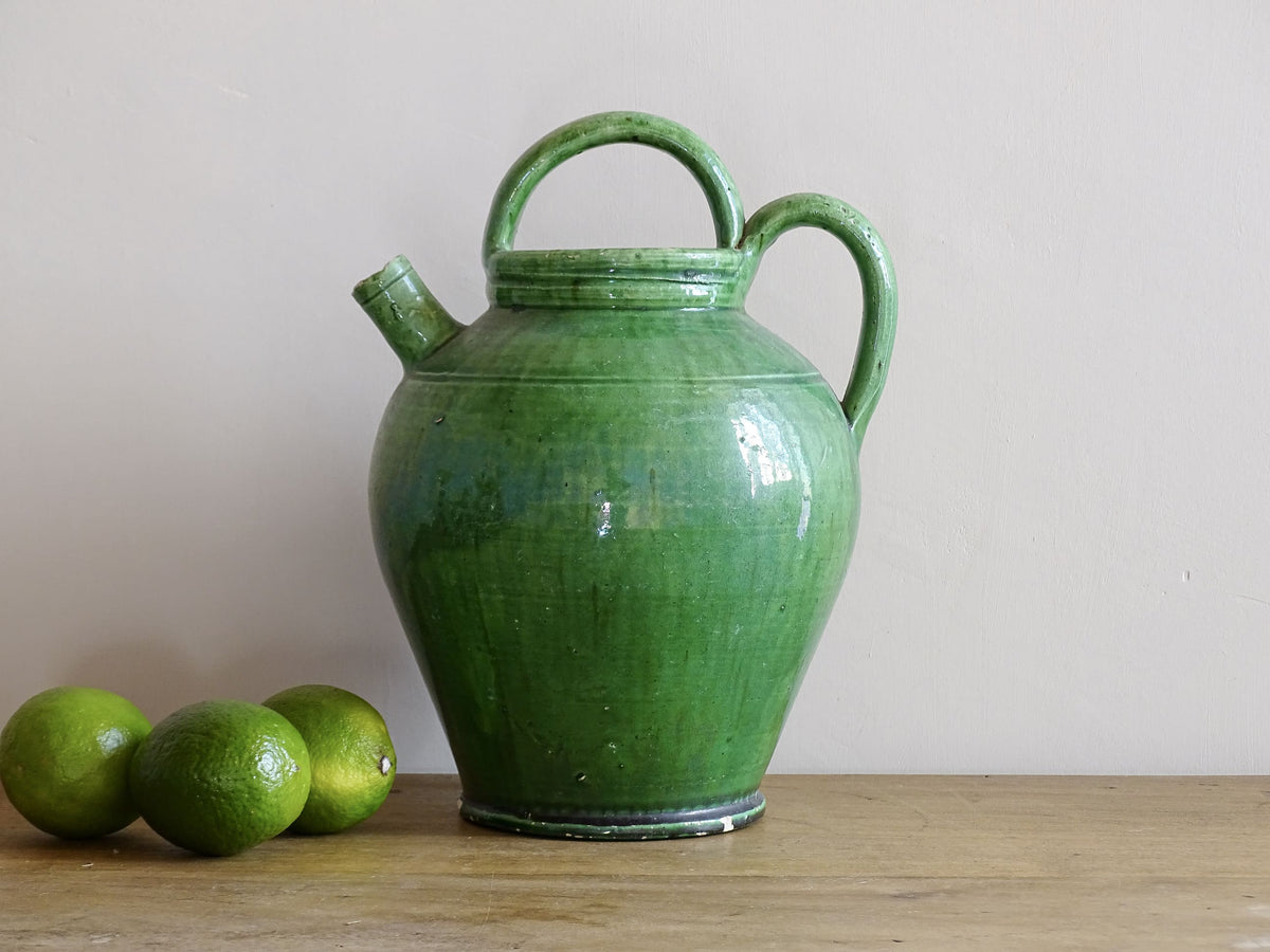 French antique gargoulette with green glaze from Provence. This antique Provençal water pitcher has a spout and two handles with a vivid green glaze. Pottery cruche.