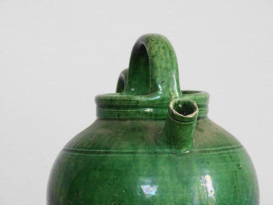 French antique gargoulette with green glaze from Provence. This antique Provençal water pitcher has a spout and two handles with a vivid green glaze. Pottery cruche.