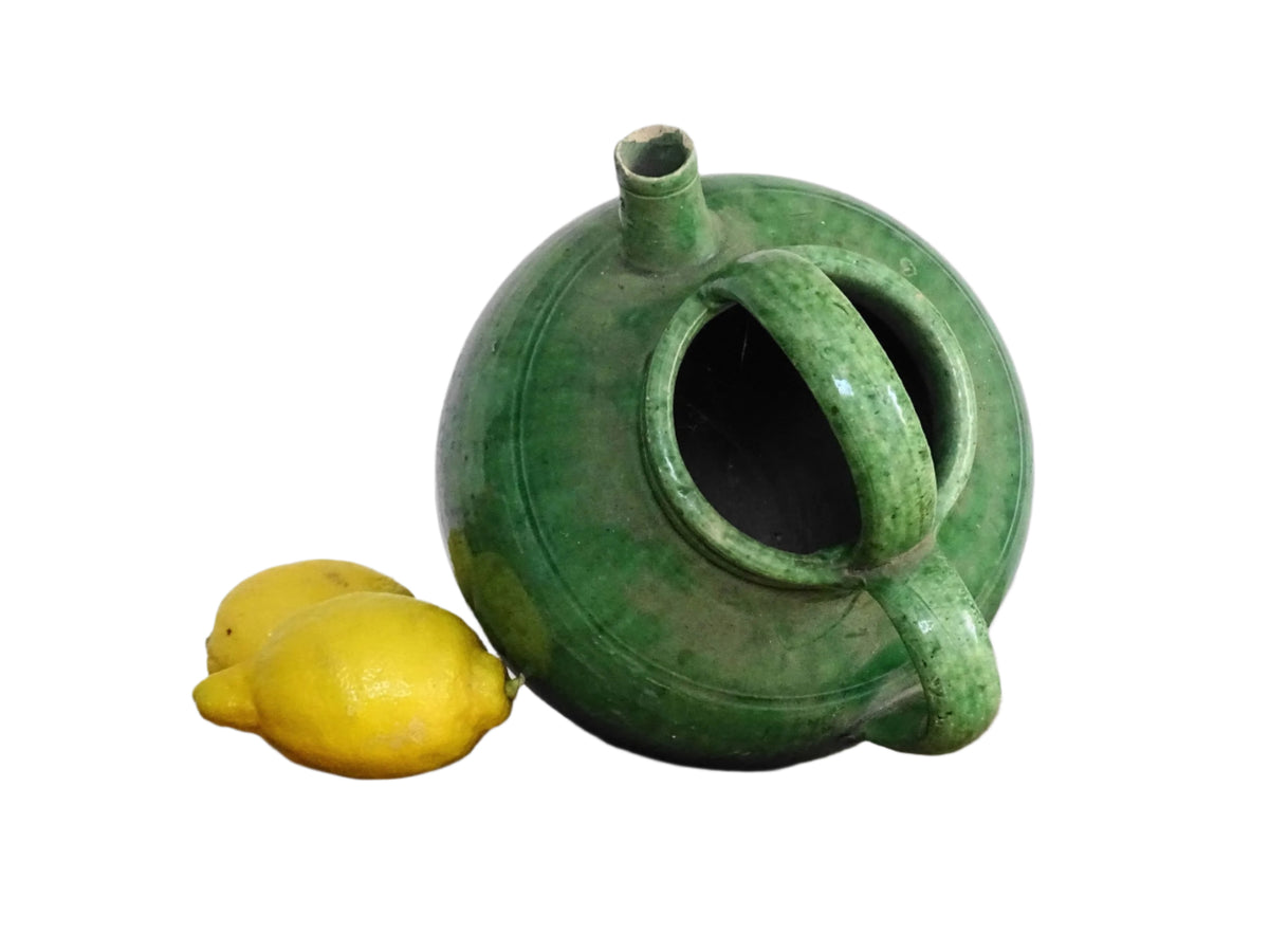 French antique gargoulette with green glaze from Provence. This antique Provençal water pitcher has a spout and two handles with a vivid green glaze. Pottery cruche.