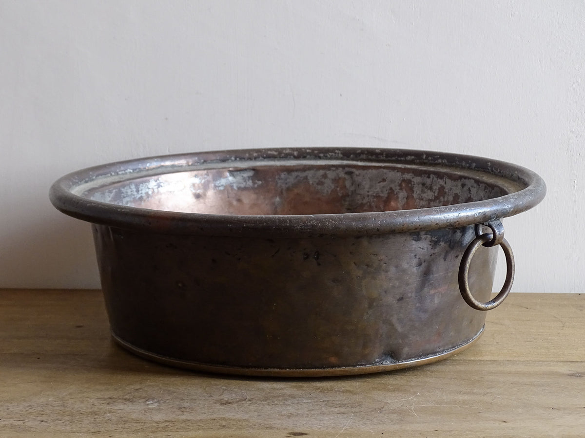 French antique copper mixing bowl with rolled top and handle. Copper bowl with timeworn appearance for a French country farmhouse kitchen.