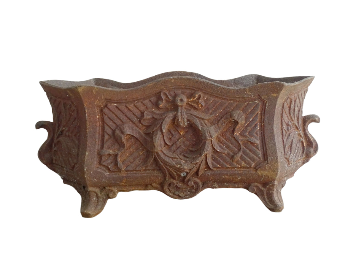Antique French cast iron jardiniere or antique planter, 19th century, with a gorgeous patina. It is on four feet and has a wreath and ribbon motif decorating it. French outdoor decor.