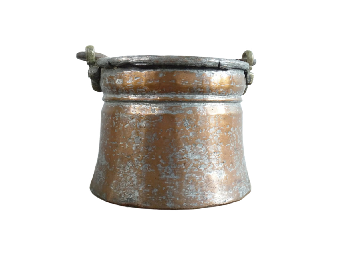 French antique tinned copper cauldron with brass detailing. A small antique copper cauldron with patina. A planter or utensil holder in a French country farmhouse kitchen.