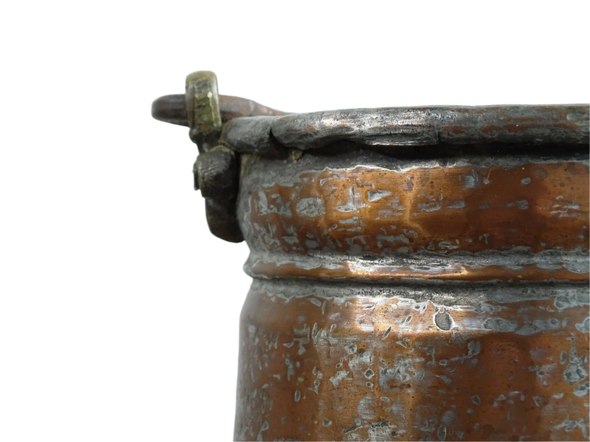 French antique tinned copper cauldron with brass detailing. A small antique copper cauldron with patina. A planter or utensil holder in a French country farmhouse kitchen.