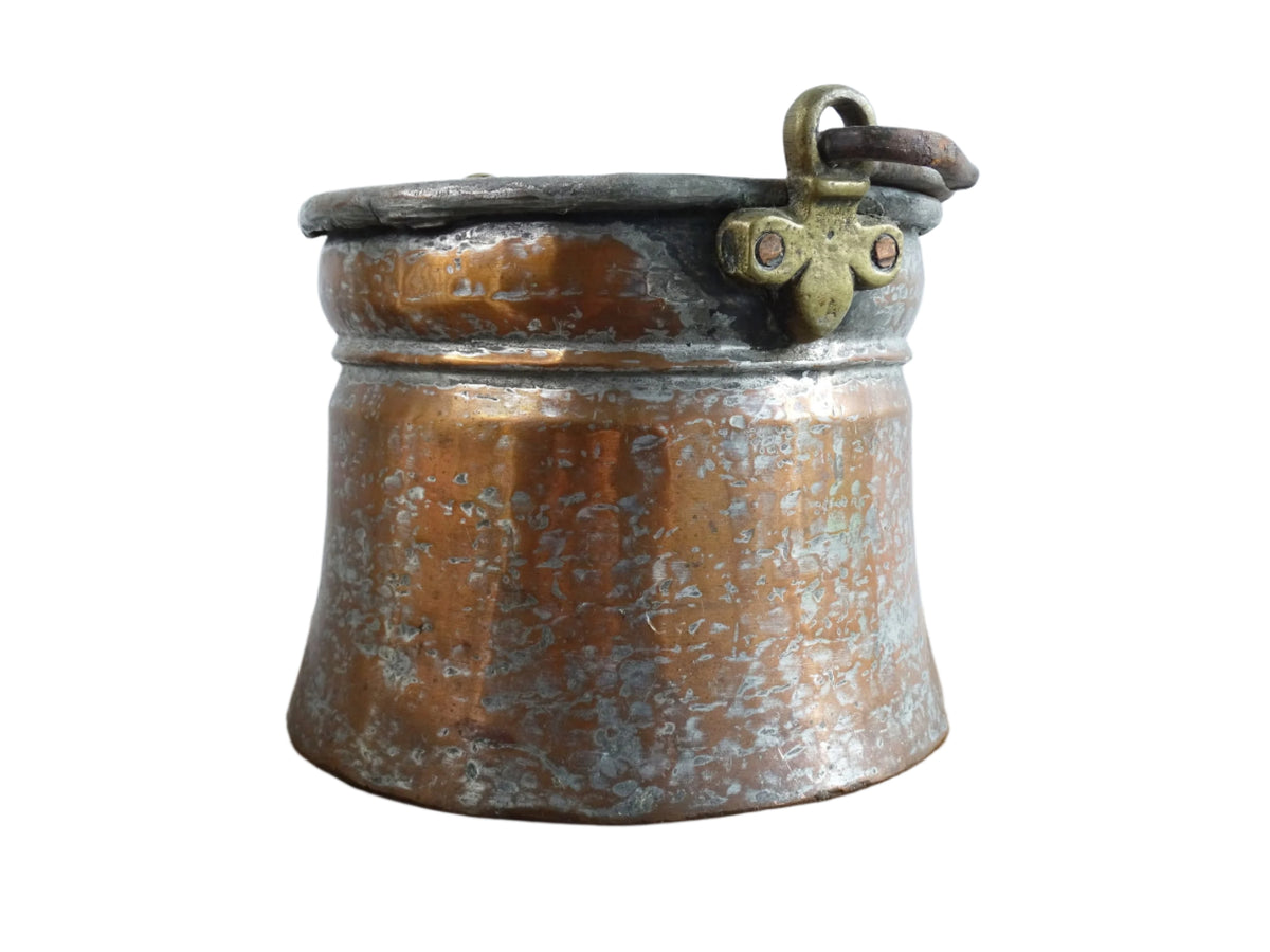 French antique tinned copper cauldron with brass detailing. A small antique copper cauldron with patina. A planter or utensil holder in a French country farmhouse kitchen.