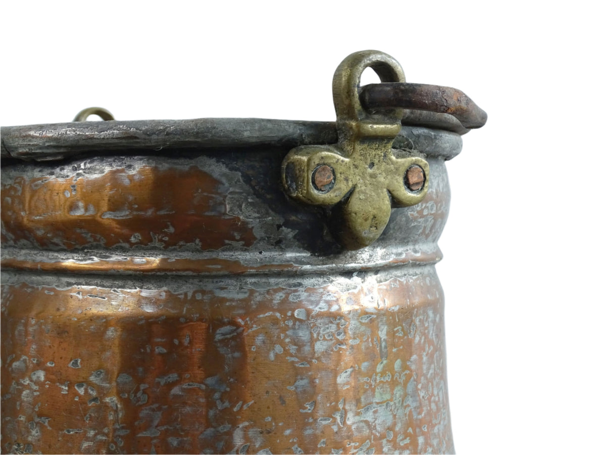 French antique tinned copper cauldron with brass detailing. A small antique copper cauldron with patina. A planter or utensil holder in a French country farmhouse kitchen.