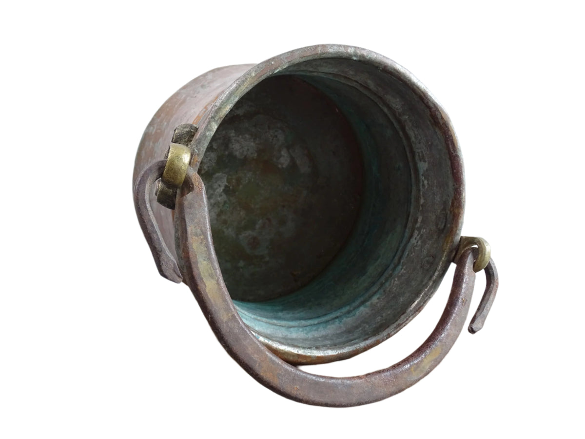 French antique tinned copper cauldron with brass detailing. A small antique copper cauldron with patina. A planter or utensil holder in a French country farmhouse kitchen.