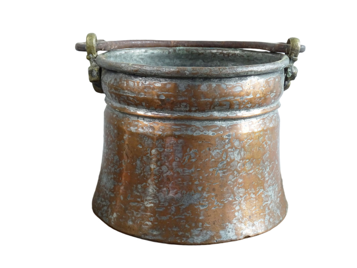 French antique tinned copper cauldron with brass detailing. A small antique copper cauldron with patina. A planter or utensil holder in a French country farmhouse kitchen.