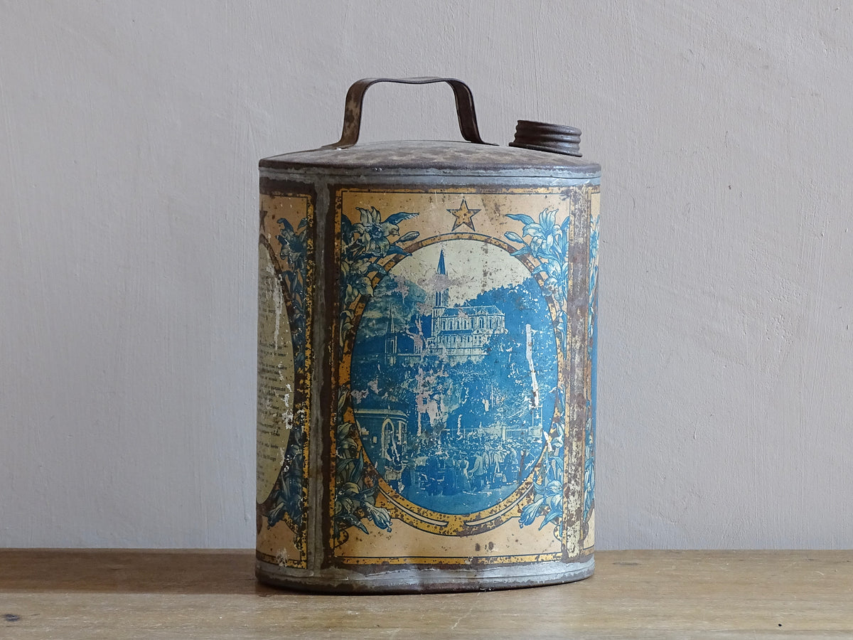 French antique Lourdes souvenir water flask. Pewter tin where the top is decorated with fleur de lis, one side depicts the cathedral (Sanctuaire de Notre-Dame de Lourdes), the other shows a crowd of people. To the side is the Virgin Mary, above her it says “Je suis l'Immaculée Conception”. The antique flask for religious decor.