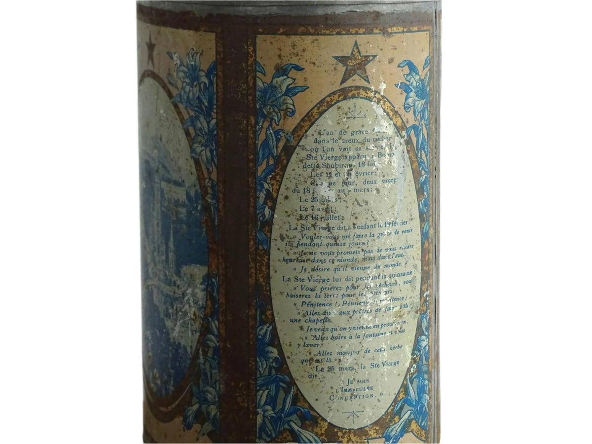 French antique Lourdes souvenir water flask. Pewter tin where the top is decorated with fleur de lis, one side depicts the cathedral (Sanctuaire de Notre-Dame de Lourdes), the other shows a crowd of people. To the side is the Virgin Mary, above her it says “Je suis l'Immaculée Conception”. The antique flask for religious decor.