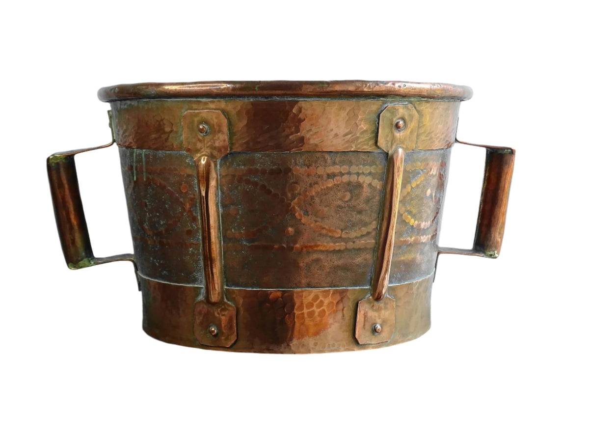 Antique hammered copper bucket from France with aged surface and riveted detail, once used to carry water, shown on a white background.