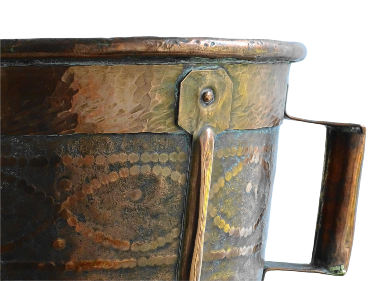 Antique hammered copper bucket from France with aged surface and riveted detail, once used to carry water, shown on a white background.