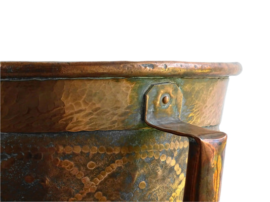 Antique hammered copper bucket from France with aged surface and riveted detail, once used to carry water, shown on a white background.