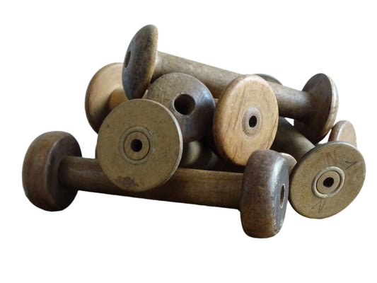 Antique and Vintage Wooden Bobbins with patina. Collection of old wood bobbins for display.