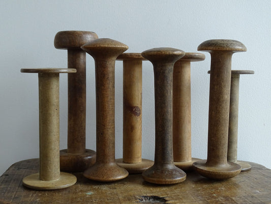 Antique and Vintage Wooden Bobbins with patina. Collection of old wood bobbins for display.