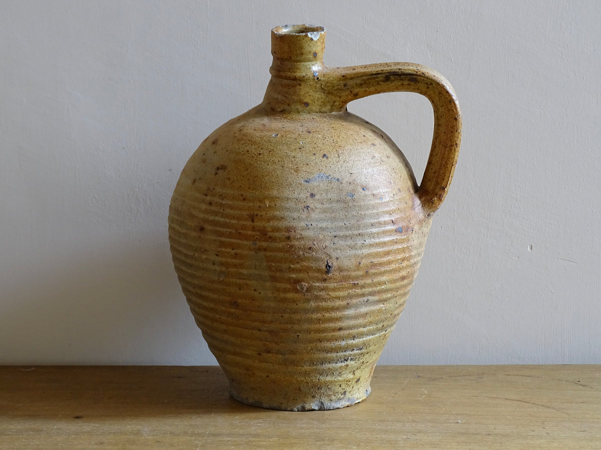 Rustic French antique pottery pitcher with orange and natural tones. Antique pitcher with rich texture for a rustic farmhouse kitchen.