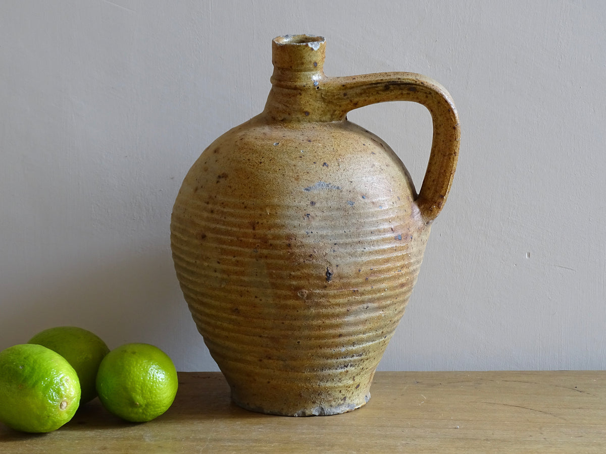 Rustic French antique pottery pitcher with orange and natural tones. Antique pitcher with rich texture for a rustic farmhouse kitchen.