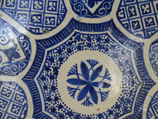 A Moroccan antique blue and white terracotta plate with intricate hand-painted geometric and floral patterns, perfect for Moroccan decor. This decorative plate for wall art or tabletop display showcases traditional pottery craftsmanship with glazed detailing.