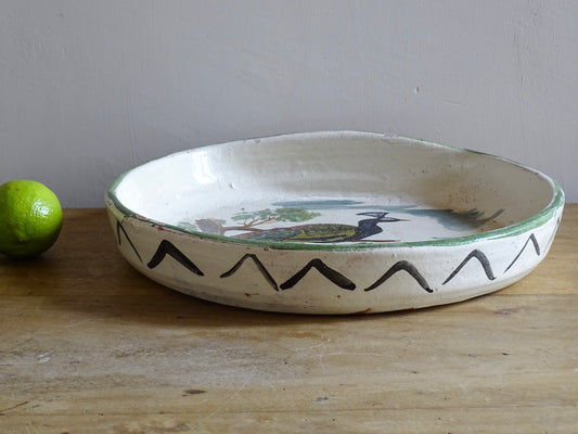 French antique glazed terracotta bowl, with hand-painted green highlights and a peacock motif to the centre. The pottery bowl is flat to the top, it is a decorative bowl for the coffee table or as wall decor.