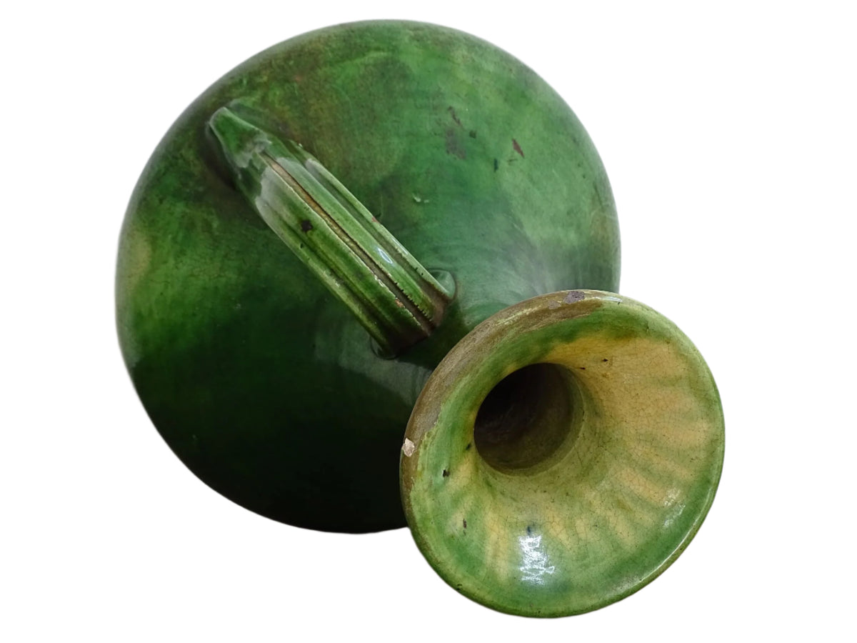 French antique art nouveau pottery vase with a green glaze in a deep tone with splashes of soft yellow. Organic in shape, this twin handled antique vase has an elongated neck