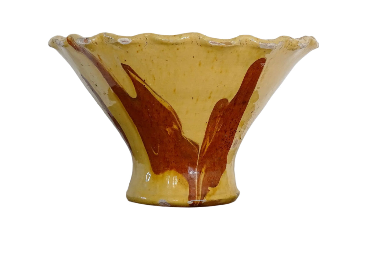 French antique terracotta bowl with yellow glaze, this earthenware basin has sweeps of a red-brown tone to the body and a crimped, pie crust style edge.