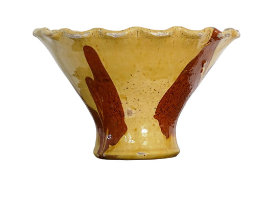 French antique terracotta bowl with yellow glaze, this earthenware basin has sweeps of a red-brown tone to the body and a crimped, pie crust style edge.