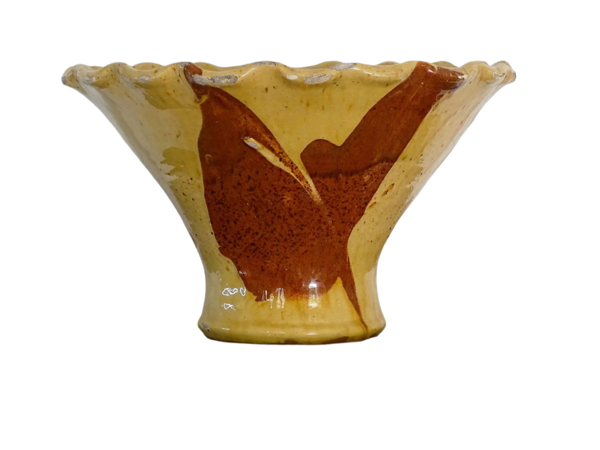 French antique terracotta bowl with yellow glaze, this earthenware basin has sweeps of a red-brown tone to the body and a crimped, pie crust style edge.