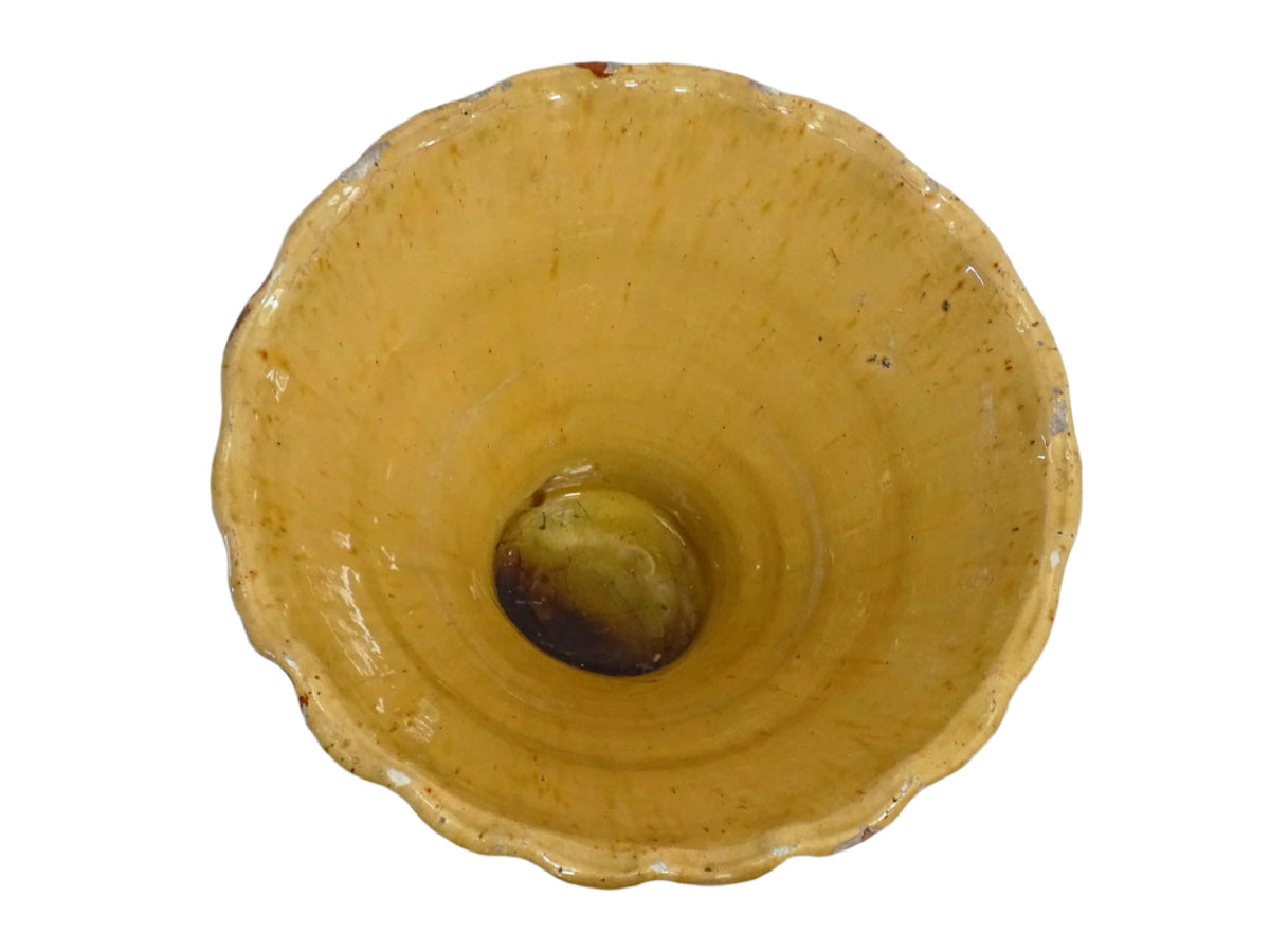 French antique terracotta bowl with yellow glaze, this earthenware basin has sweeps of a red-brown tone to the body and a crimped, pie crust style edge.