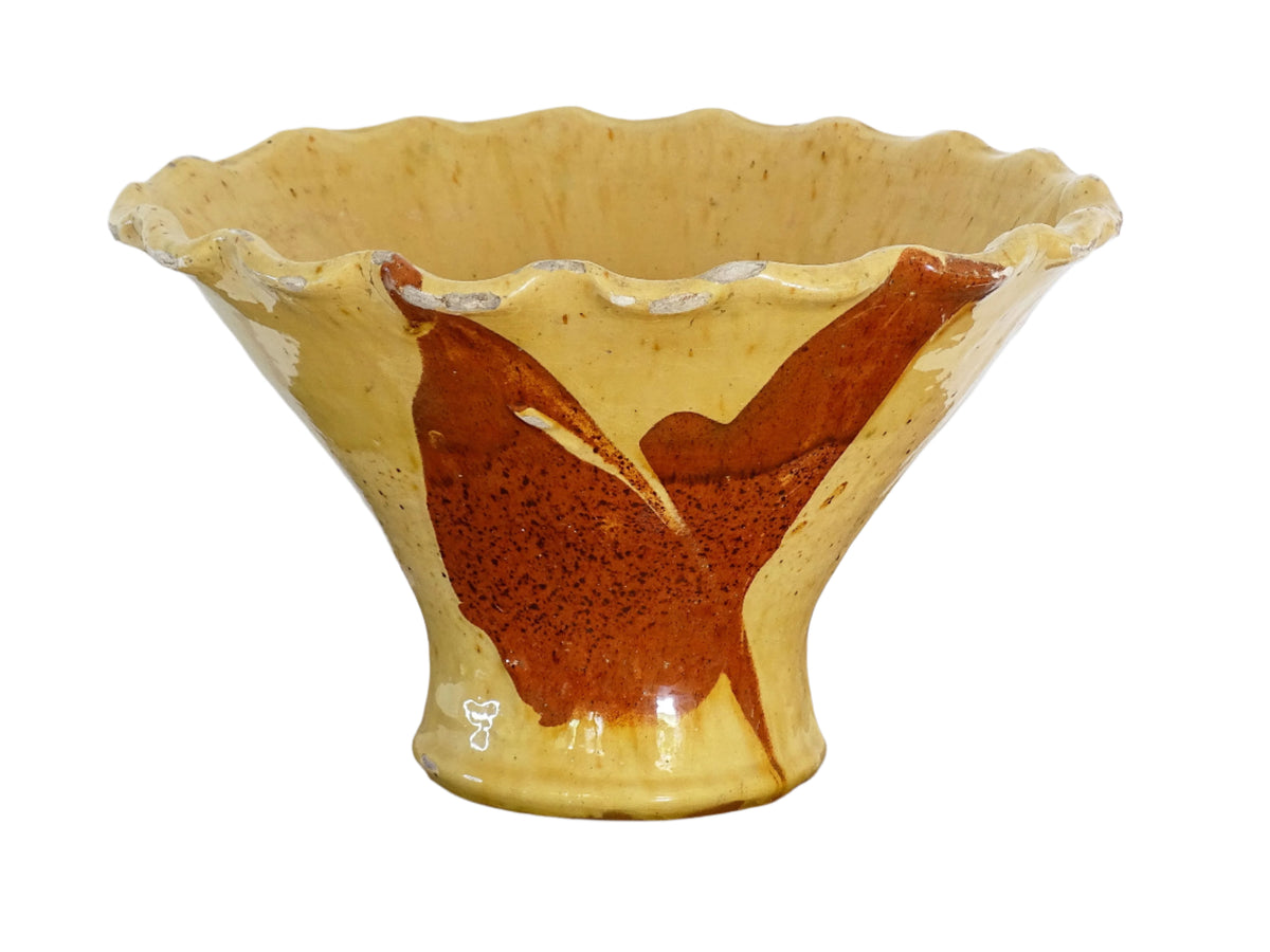 French antique terracotta bowl with yellow glaze, this earthenware basin has sweeps of a red-brown tone to the body and a crimped, pie crust style edge.