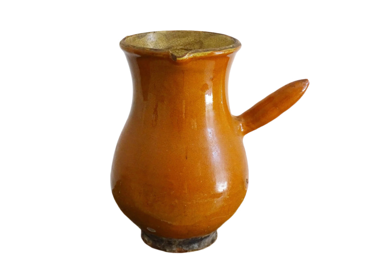 French antique terracotta jug with red glaze exterior and yellow glaze interior. Antique pottery pitcher with side handle and patina.