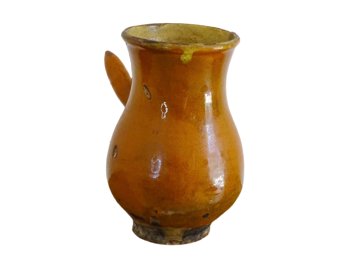 French antique terracotta jug with red glaze exterior and yellow glaze interior. Antique pottery pitcher with side handle and patina.