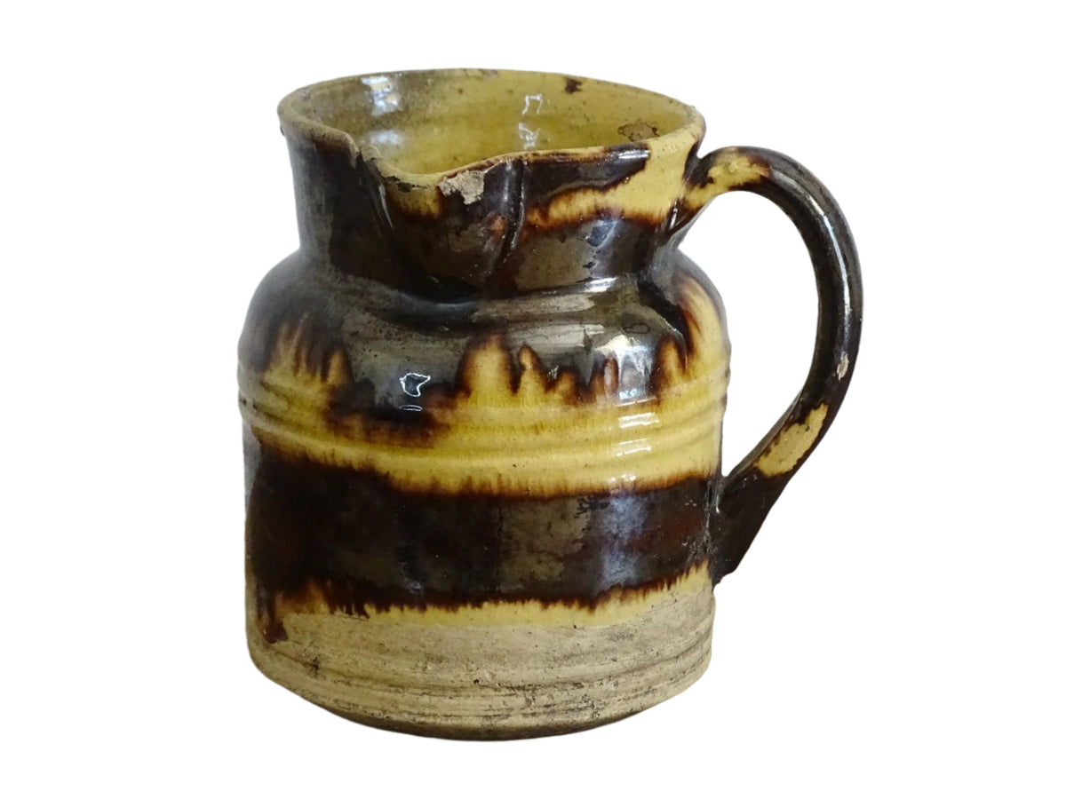 French antique ceramic jug from Dieulefit with brown drip glaze and yellow glazed background.