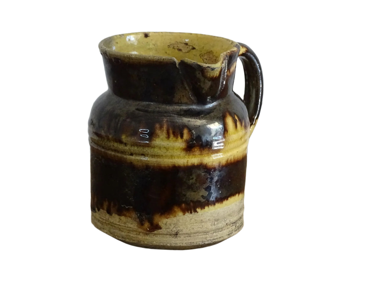 French antique ceramic jug from Dieulefit with brown drip glaze and yellow glazed background.