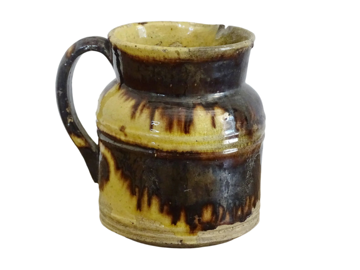 French antique ceramic jug from Dieulefit with brown drip glaze and yellow glazed background.