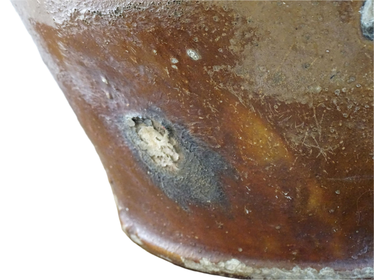 French antique pottery orjol or cruche with a golden caramel and yellow glaze. Glazed antique terracotta pitcher has two handles and a spout with a rounded body. Earthenware pottery for an antique French farmhouse style aesthetic.