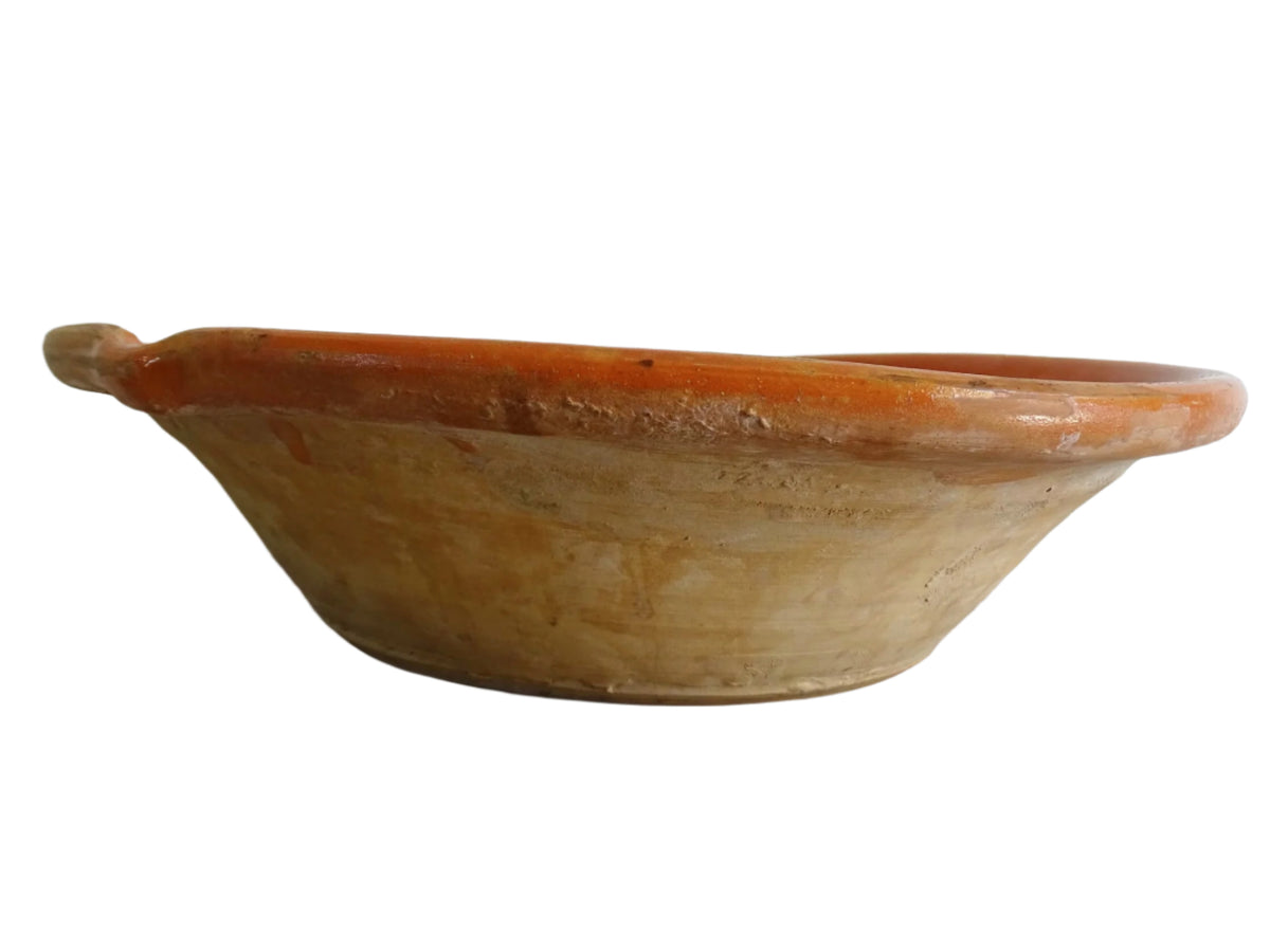French antique pottery cheese strainer or faisseller. Shaped like a French tian bowl with a stand in the middle and a lip to the edge. Rustic French antique pottery bowl with an orange glaze. Glazed earthenware cheese drainer.