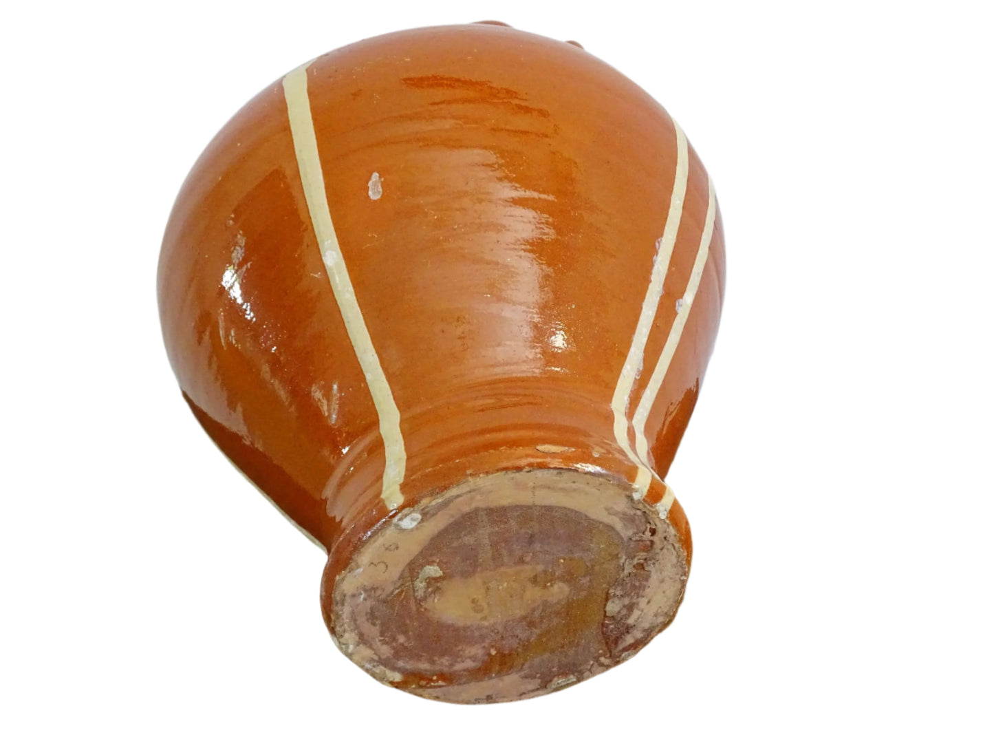 Rustic French antique pottery cruche or gargoulette with a deep red glaze and yellow stripe detailing. The body of this terracotta pitcher is a rounded shape with a handle to the top and two spouts. Glazed pottery water jug for a Provençal style farmhouse table.