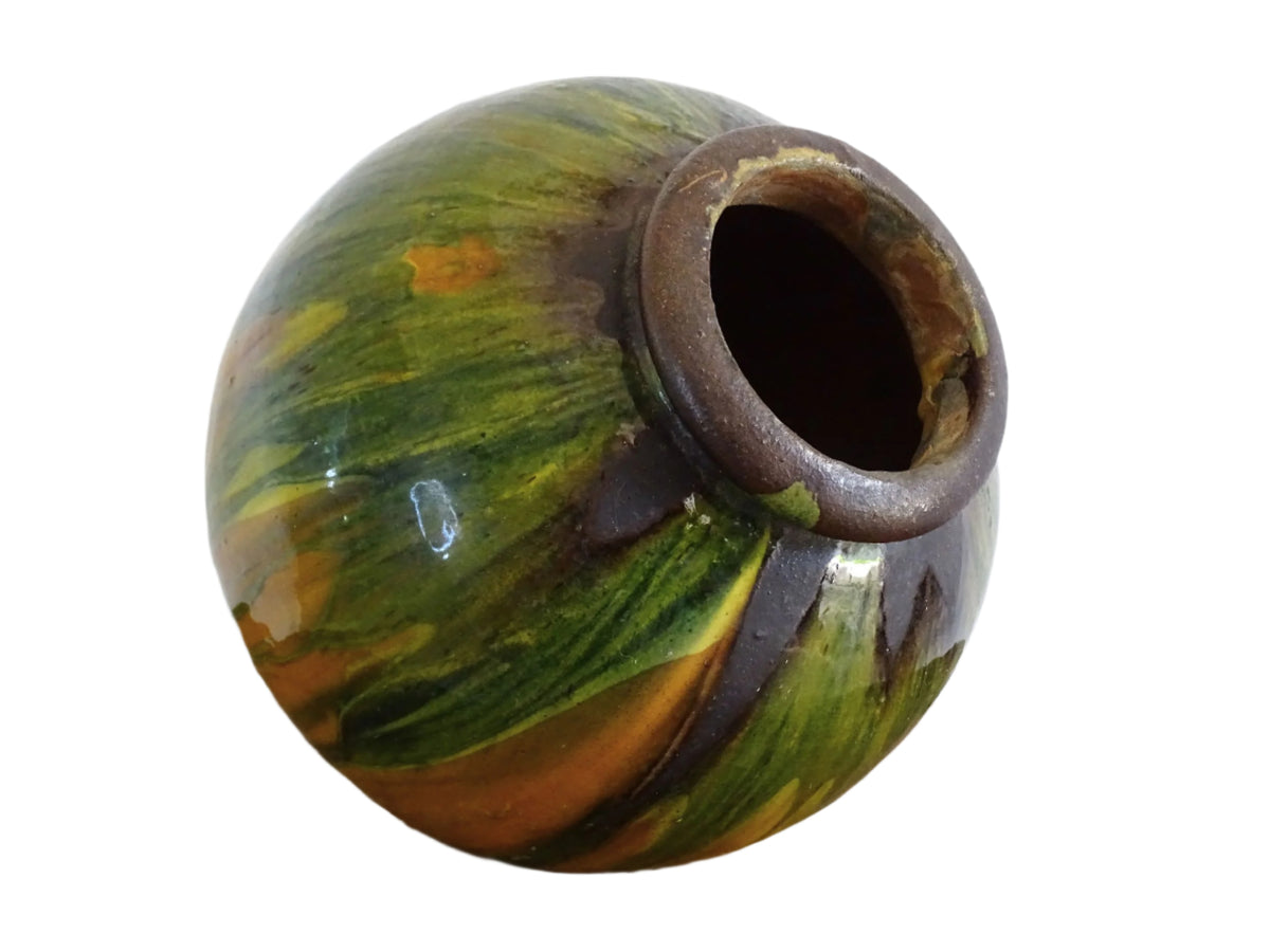 French antique ceramic vase glazed in orange with a yellow, green and brown drip glaze. Pottery vase with a rounded shape.