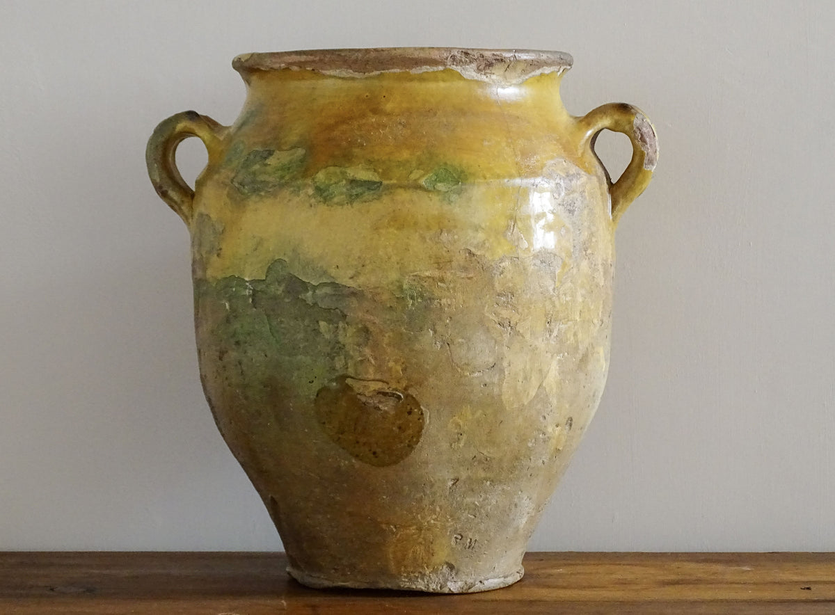 Large antique French confit pot with yellow glaze. Old terracotta pot with a rich patina and has touches of green over the mustard yellow. Yellow confit jar with two handles, farmhouse pottery for a French country farmhouse decor.