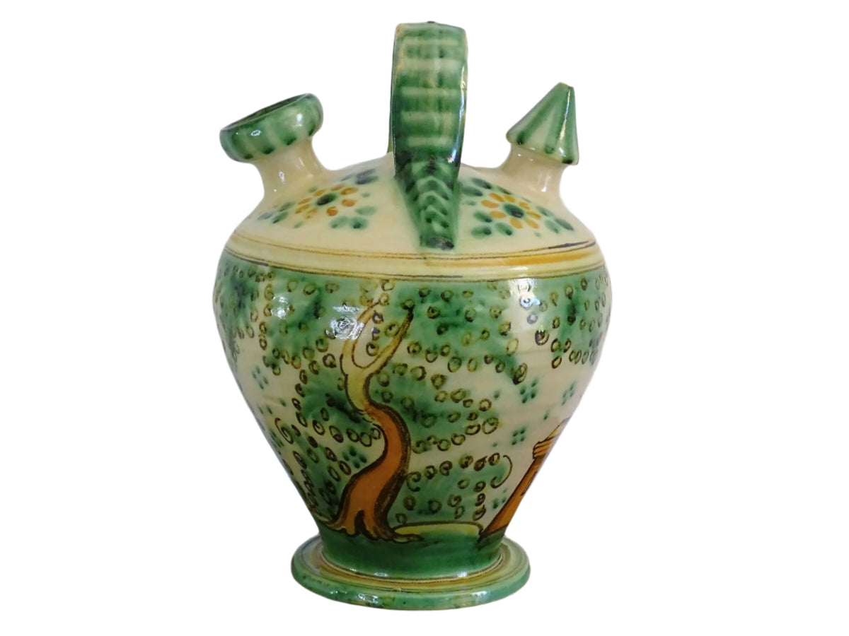 Decorated Spanish vintage gargoulette with a green and ochre yellow glaze. Puente Del Arzobispo pottery water pitcher is hand-painted with trees, a castle and flowers. It has a handle to the top, as well as two spouts. Ceramic pitcher or glazed terracotta jug.