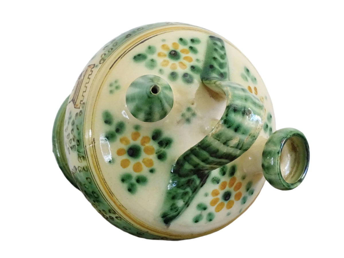 Decorated Spanish vintage gargoulette with a green and ochre yellow glaze. Puente Del Arzobispo pottery water pitcher is hand-painted with trees, a castle and flowers. It has a handle to the top, as well as two spouts. Ceramic pitcher or glazed terracotta jug.